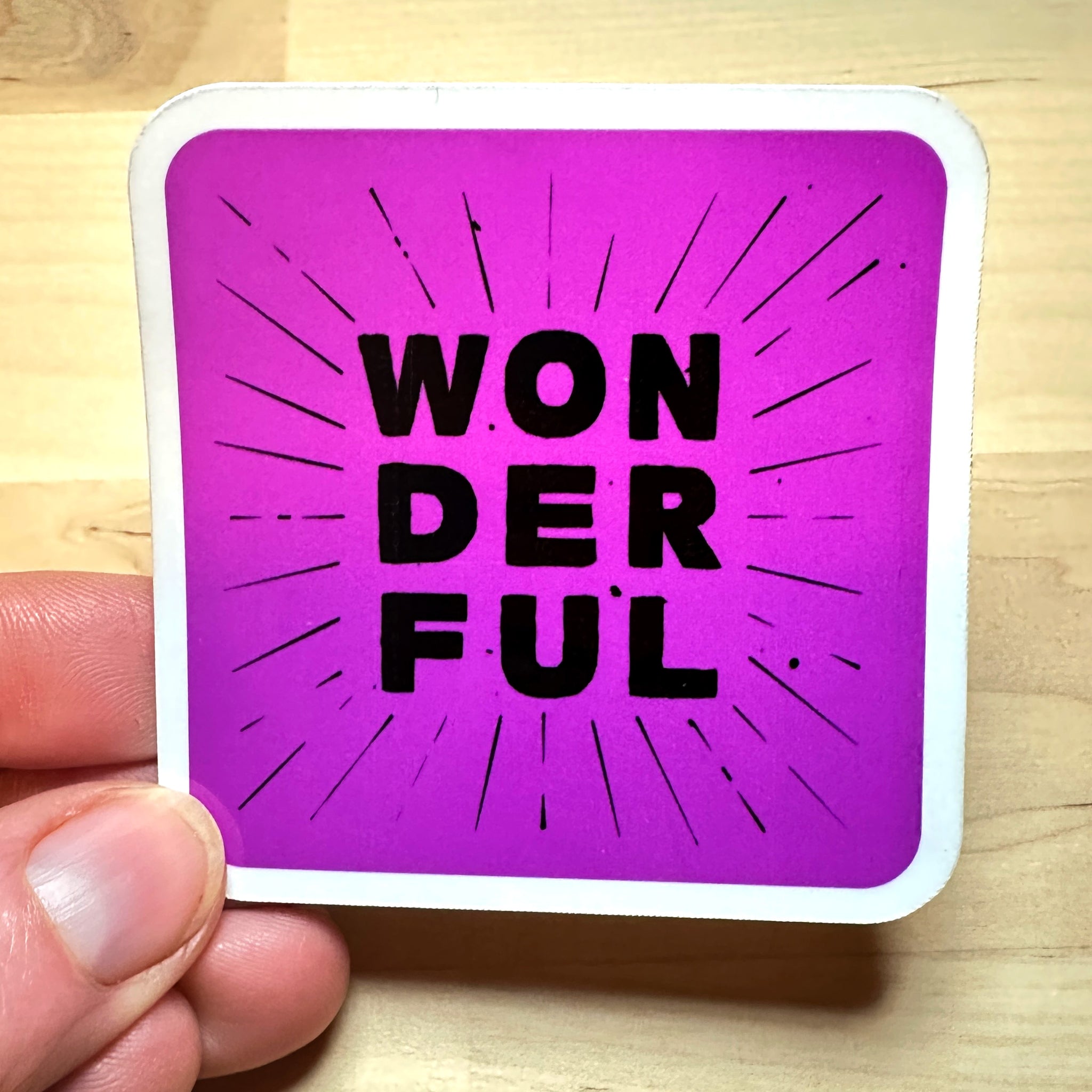 photo of waterproof vinyl sticker with the word wonderful in 3 layers of black text on purple background