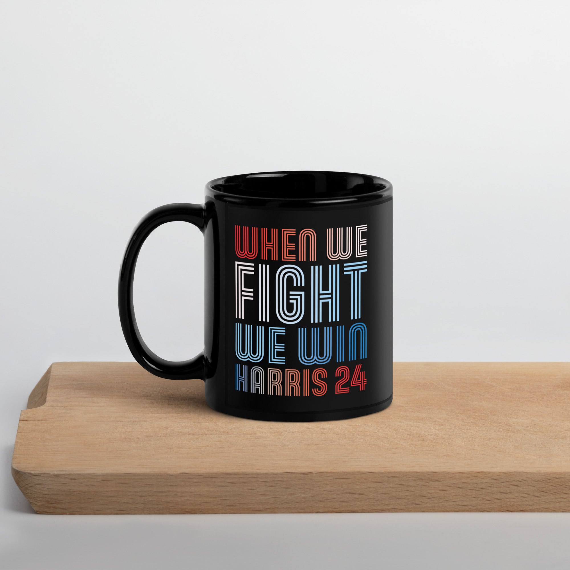 black ceramic mug with when we fight we win harris 24 in red white and blue blended text