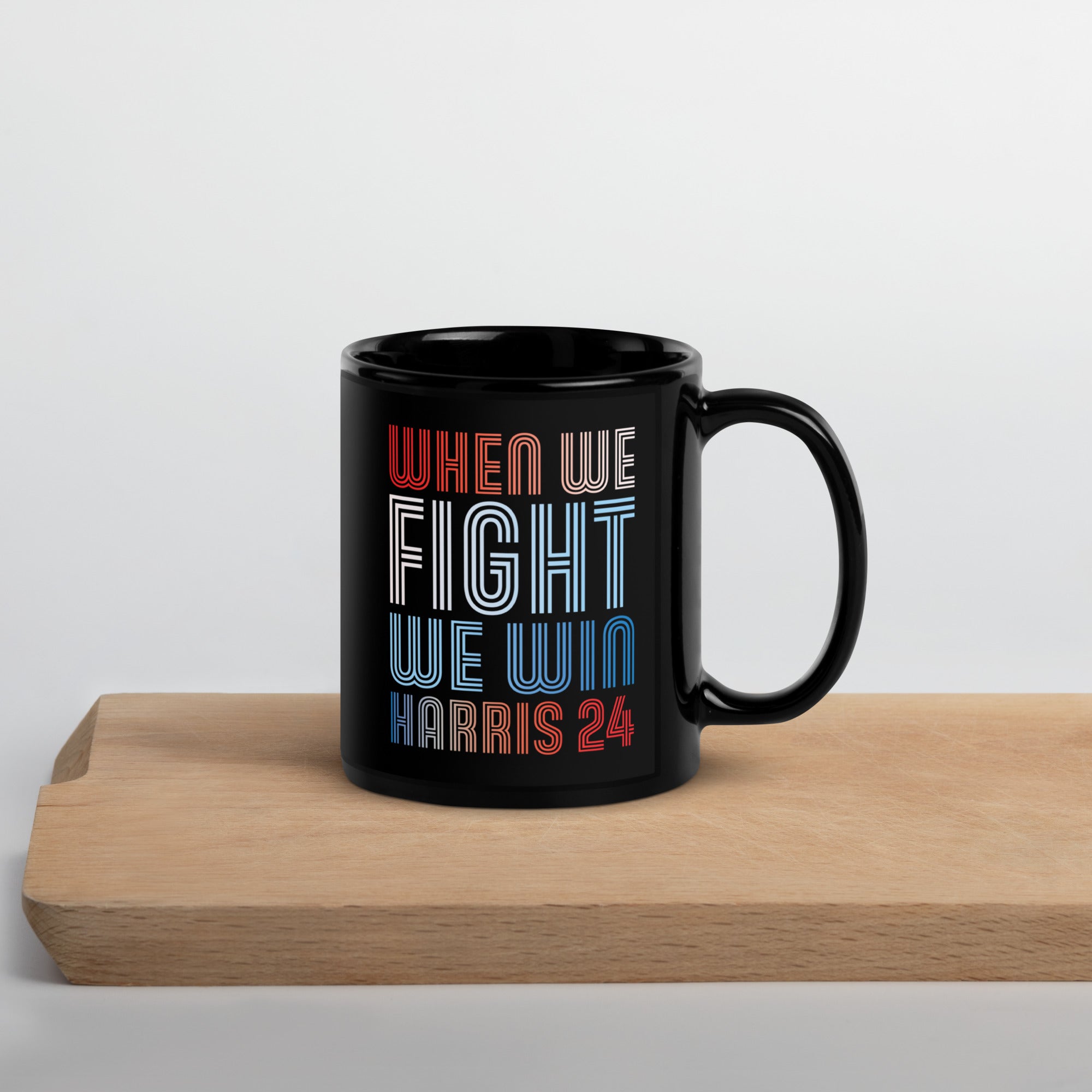 black ceramic mug with when we fight we win harris 24 in red white and blue blended text