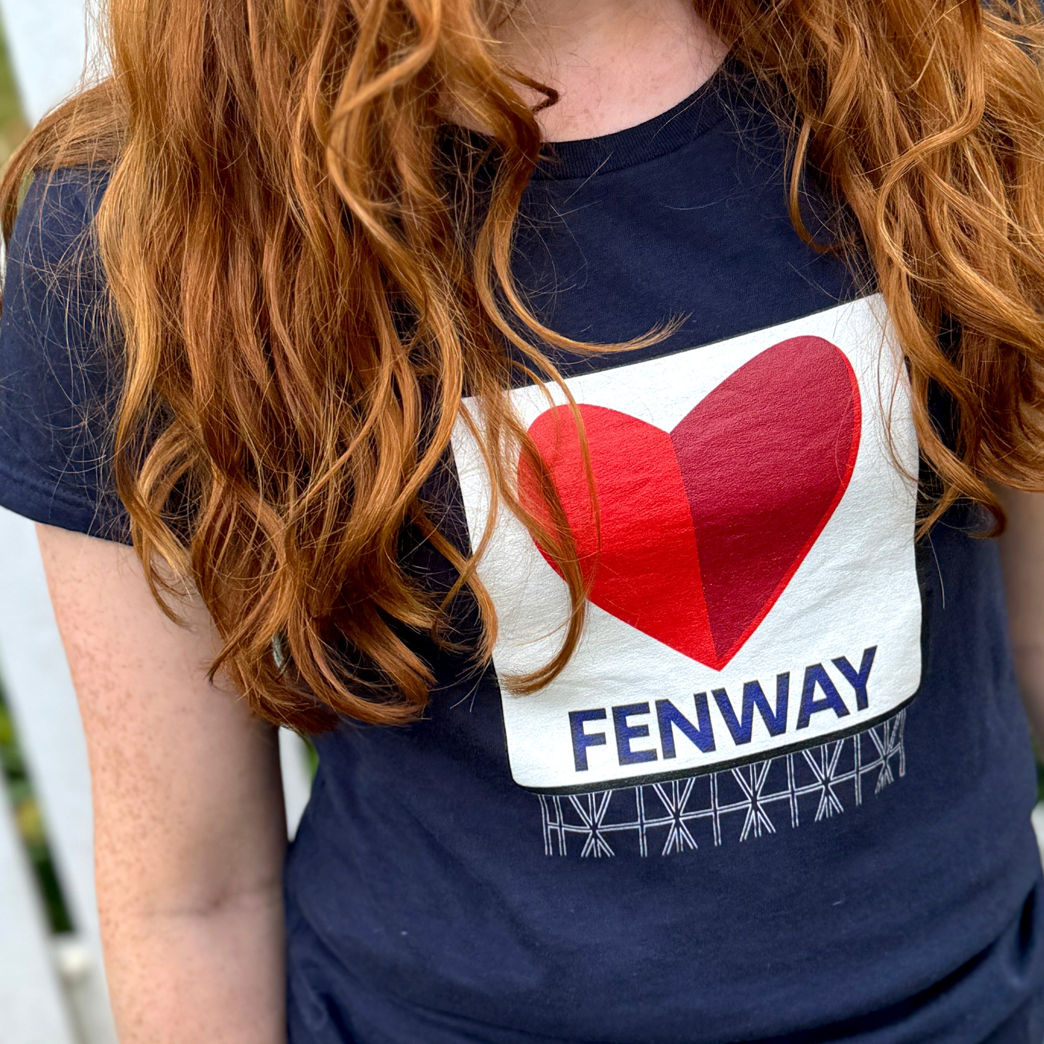 photo of woman wearing navy blue women's t-shirt with the boston fenway citgo sign in the shape of a heart