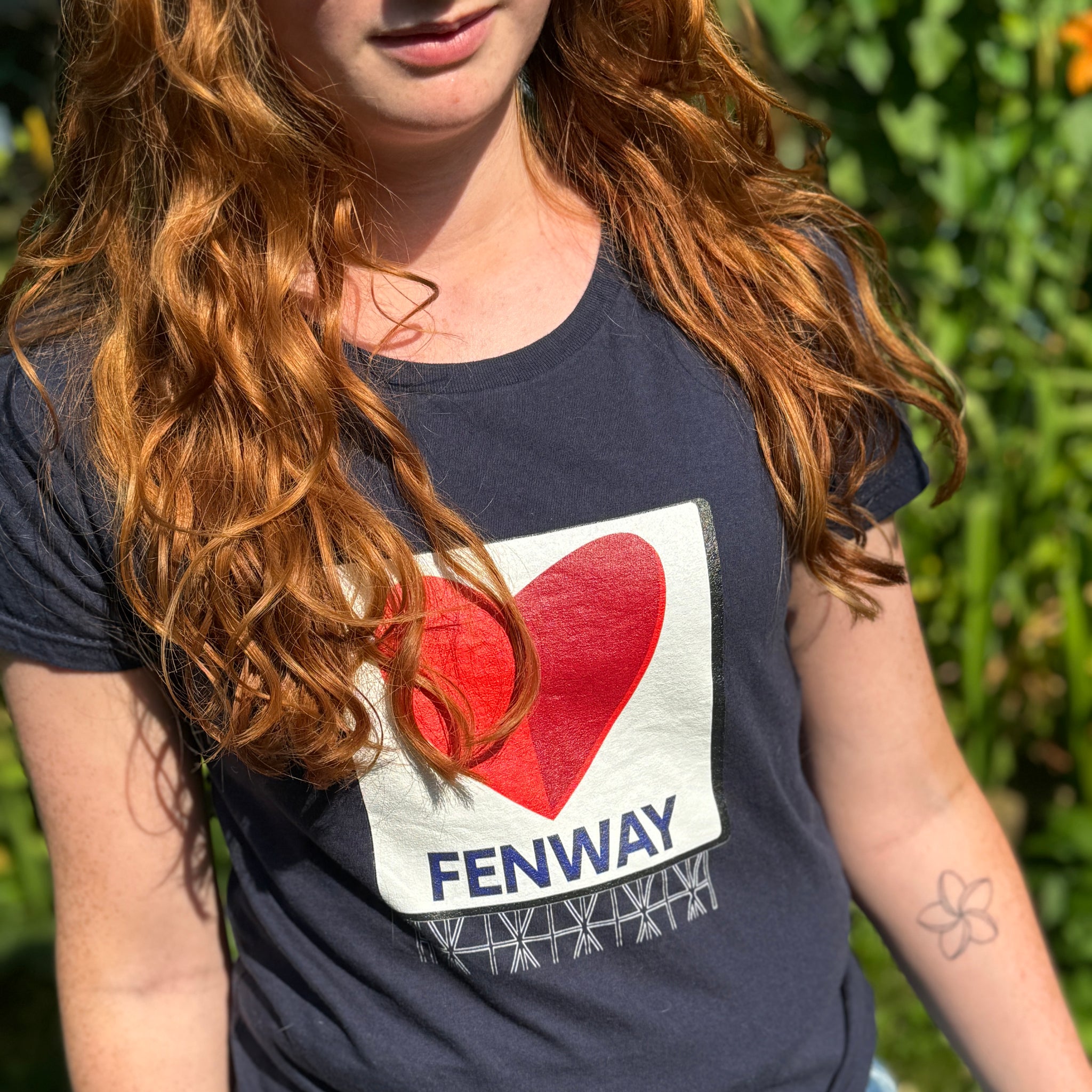 photo of woman wearing navy blue women's t-shirt with the boston fenway citgo sign in the shape of a heart