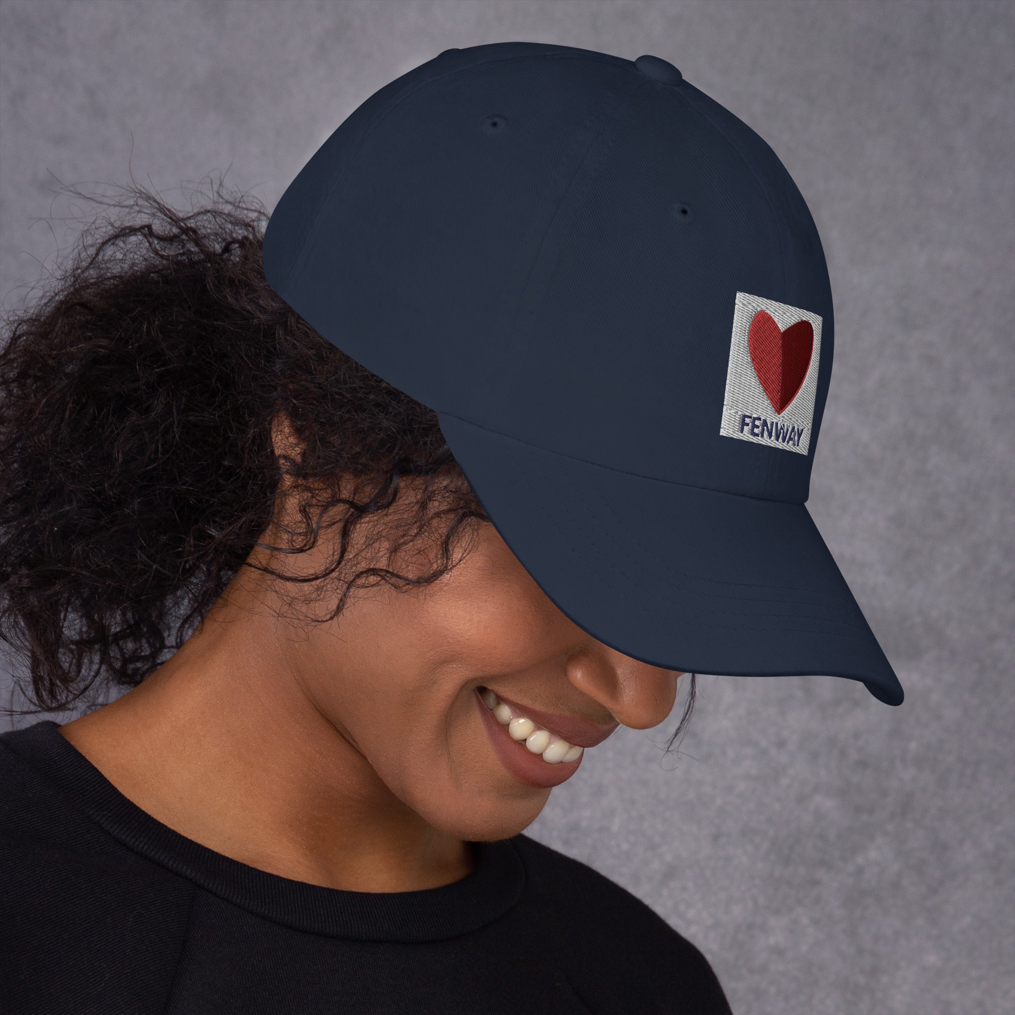 photo of woman wearing graphic of the citgo sign boston fenway as a heart embroidered on baseball hat