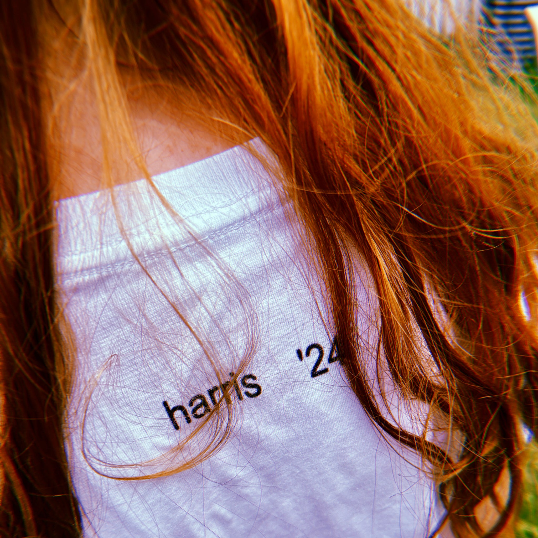 back of woman wearing white unisex t-shirt with the phrase harris 24 and charli xcx brat