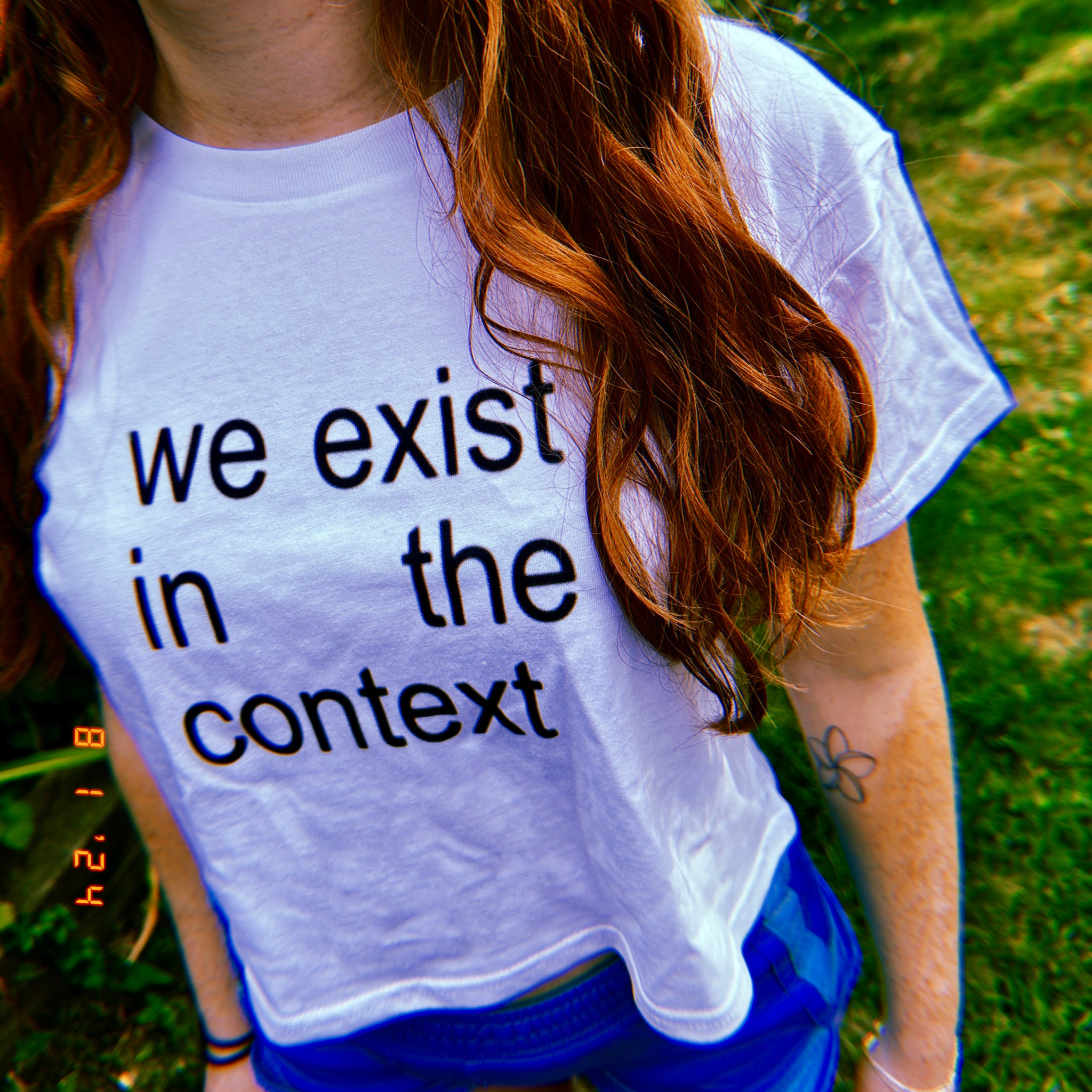 photo of woman wearing white unisex t-shirt with the phrase harris 24 and charli xcx brat