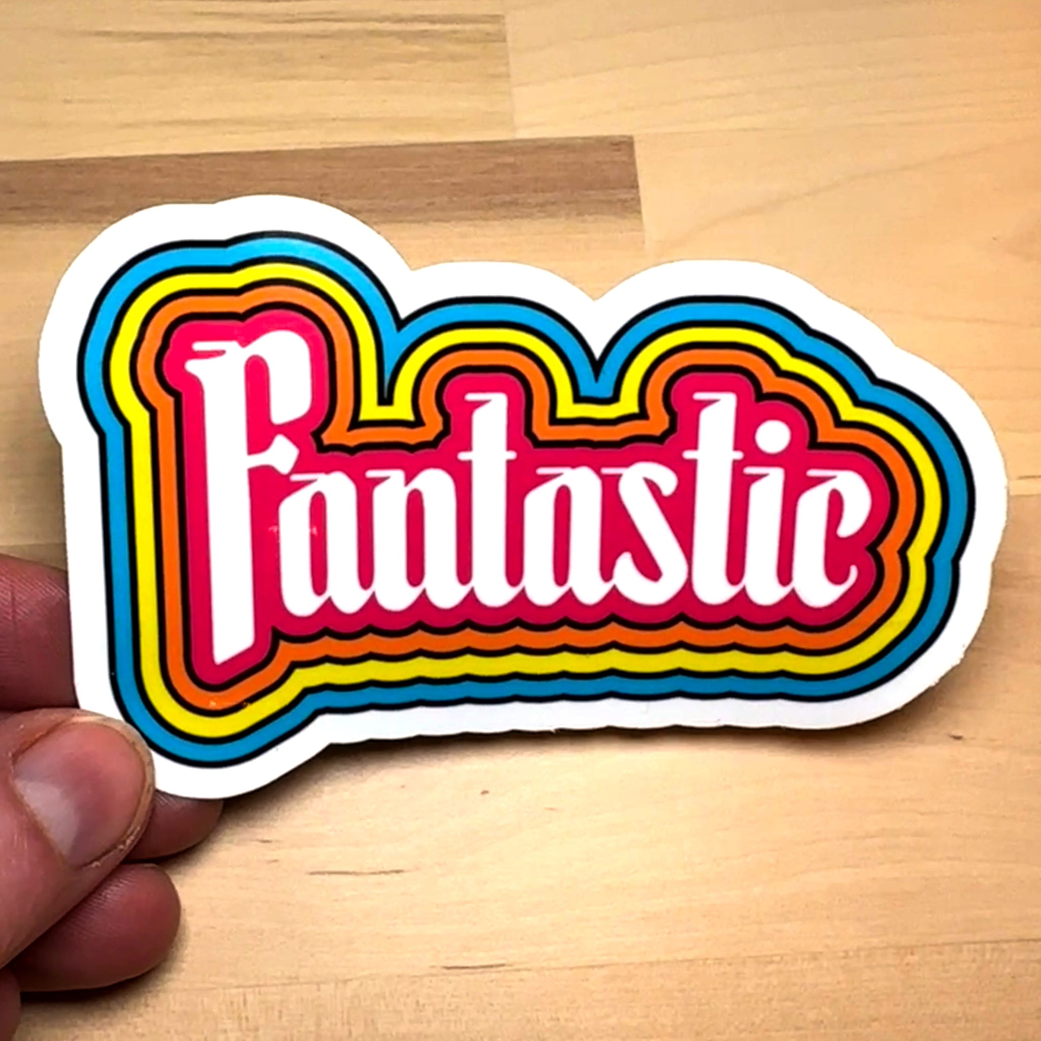 photo of a waterproof sticker that features the word "Fantastic!" with outlines of pink, orange, yellow and blue