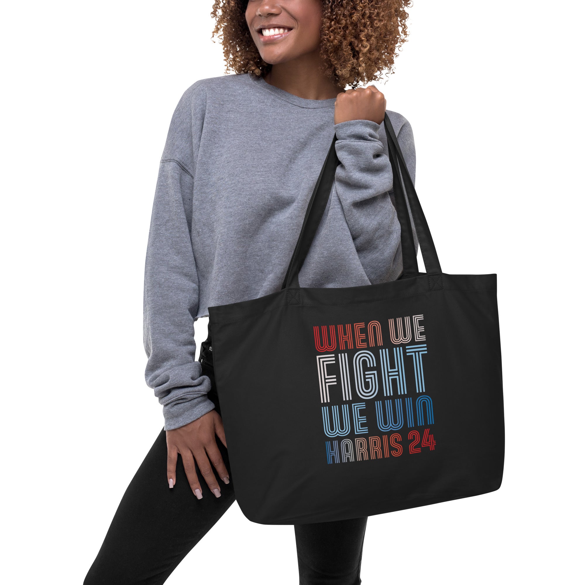 woman with black large tote bag with when we fight we win harris 24 in red white and blue blended text