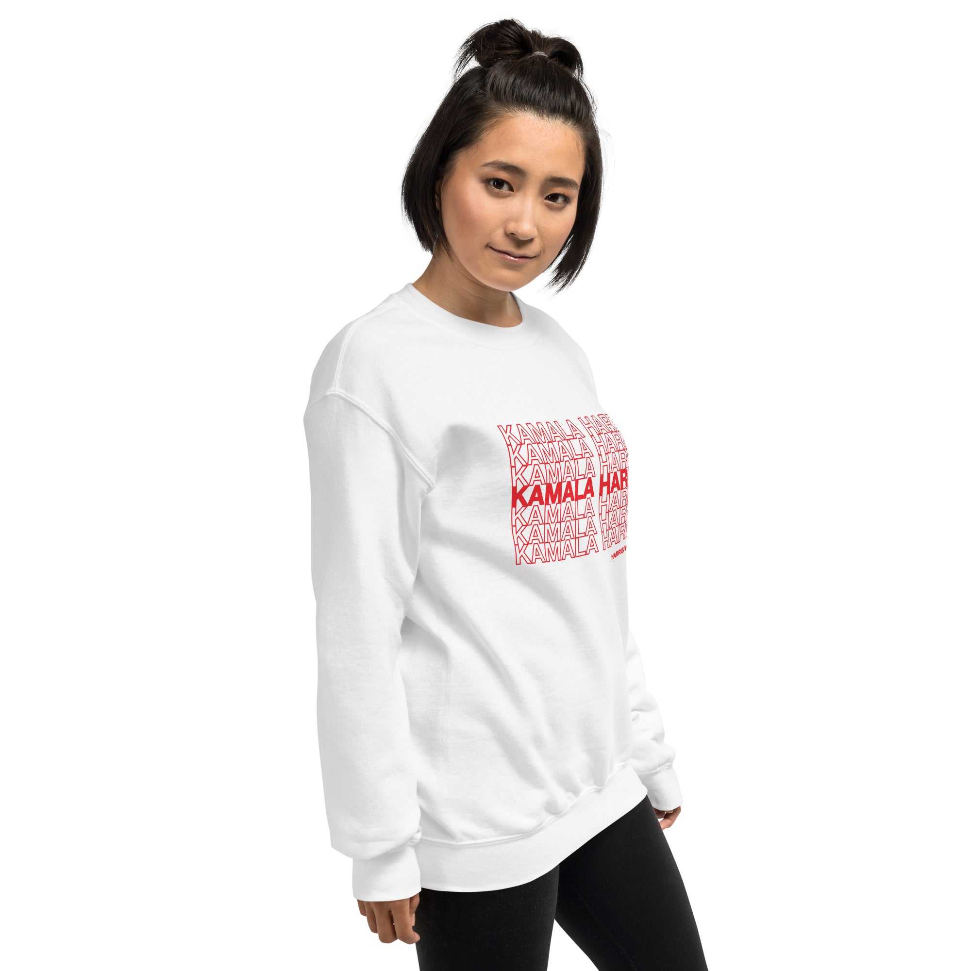 woman wearing White unisex crewneck sweatshirt with red text saying "kamala Harris" in the classic plastic shopping bag design