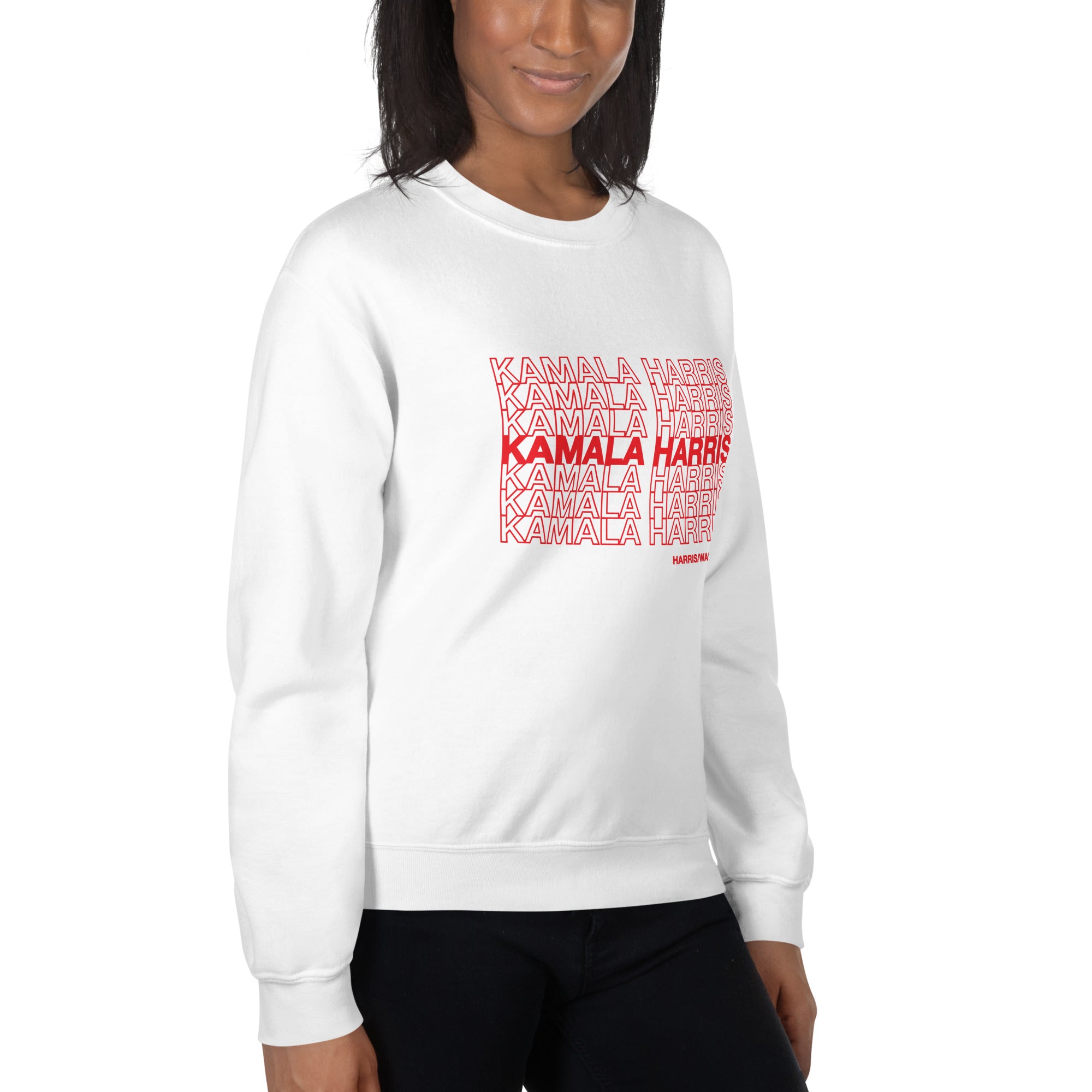 woman wearing White unisex crewneck sweatshirt with red text saying "kamala Harris" in the classic plastic shopping bag design