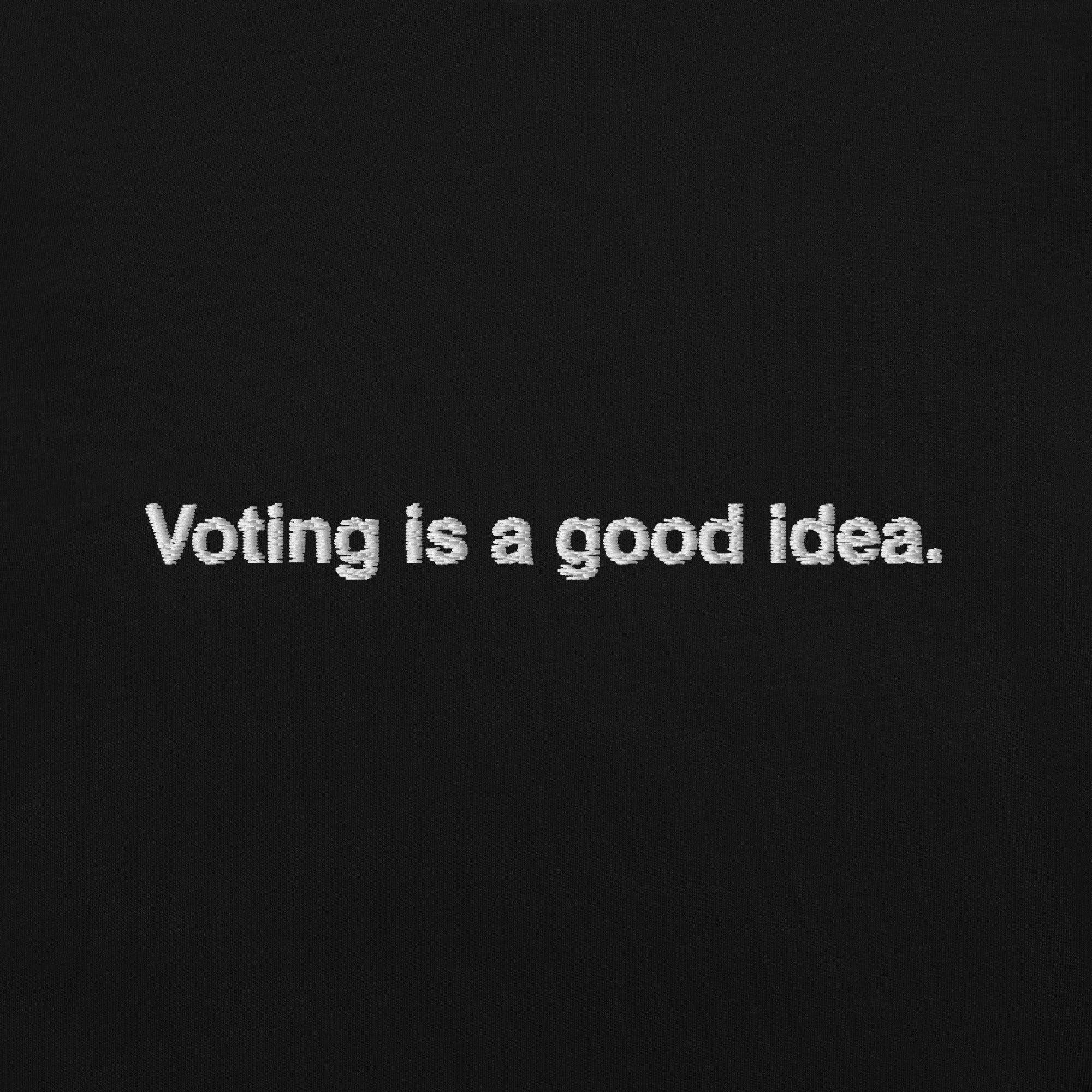 close up of black background with the phrase, voting is a good idea, embroidered in white on the front