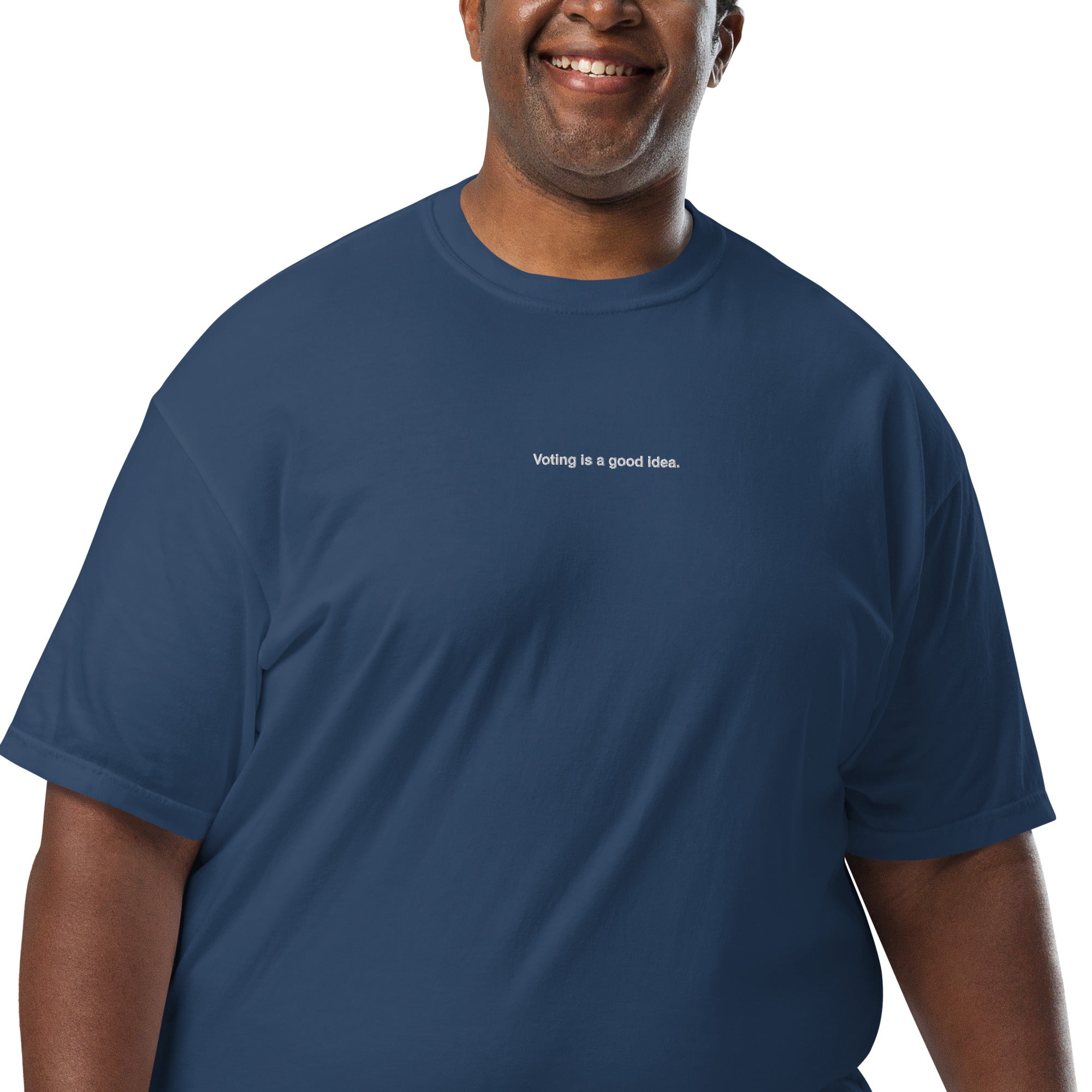 man wearing navy heavyweight unisex t-shirt with the phrase, voting is a good idea, embroidered in white on the front