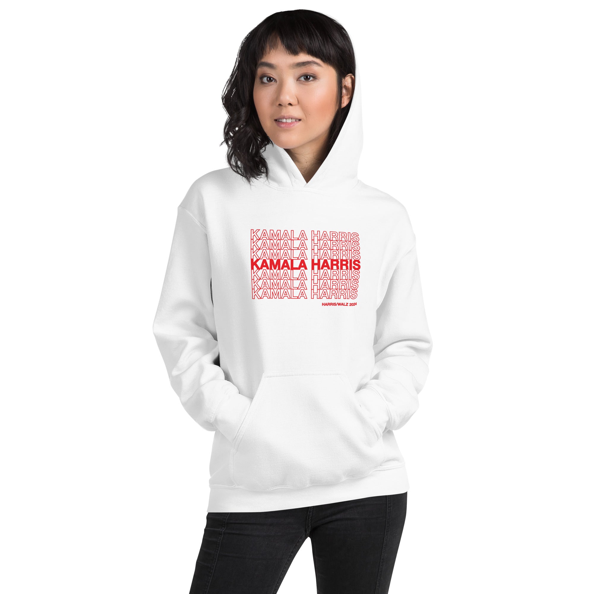 woman wearing White unisex hoodie sweatshirt with red text saying "kamala Harris" in the classic plastic shopping bag design