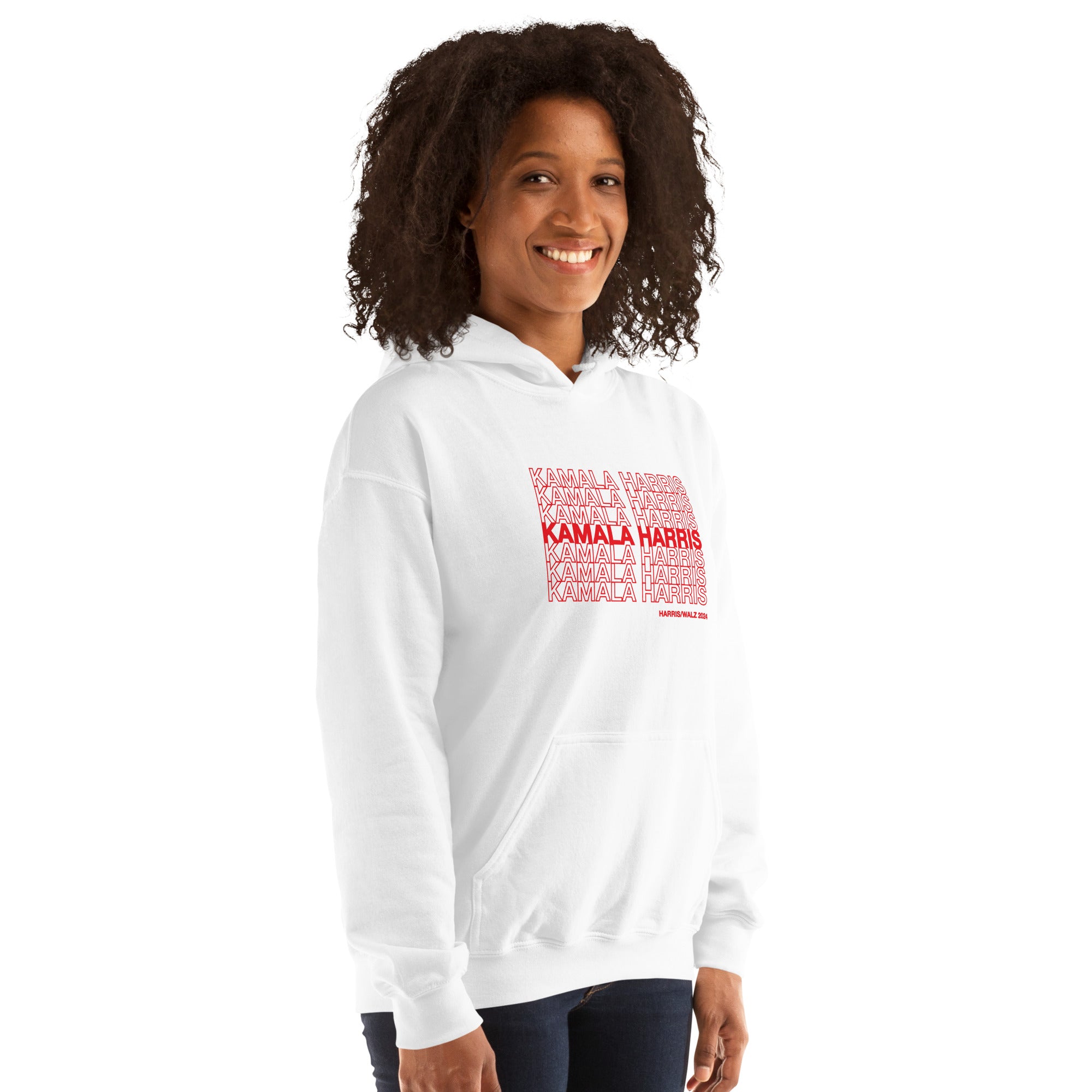 woman wearing White unisex hoodie sweatshirt with red text saying "kamala Harris" in the classic plastic shopping bag design