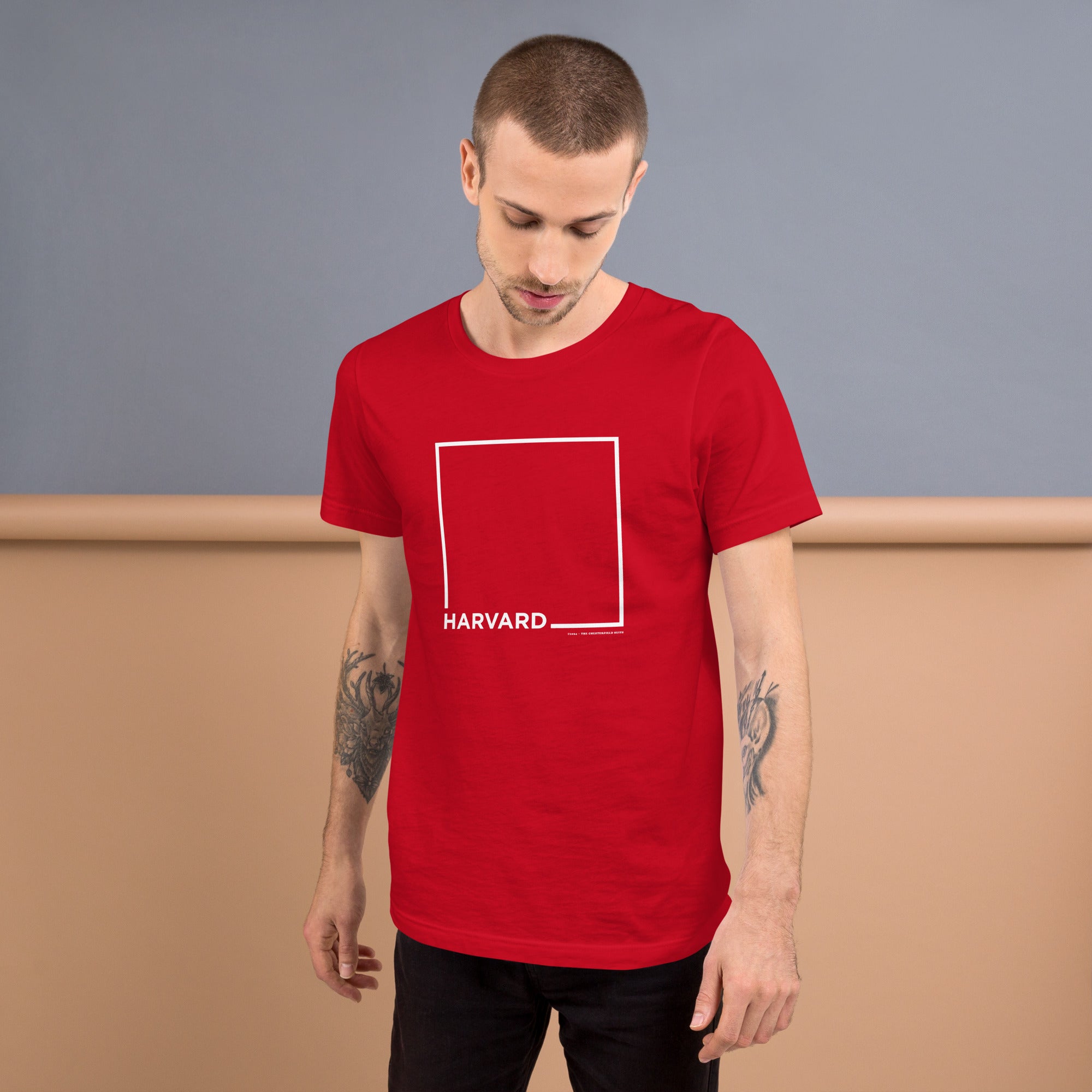 man wearing Red unisex t-shirt with the word Harvard and a white square for harvard square