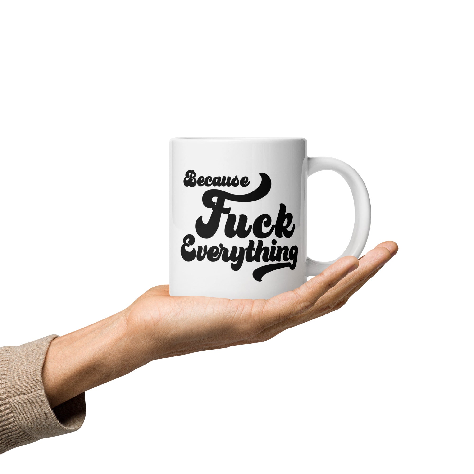 hand holding 20 oz white glossy mug with the words Because Fuck Everything in black bold cursive font