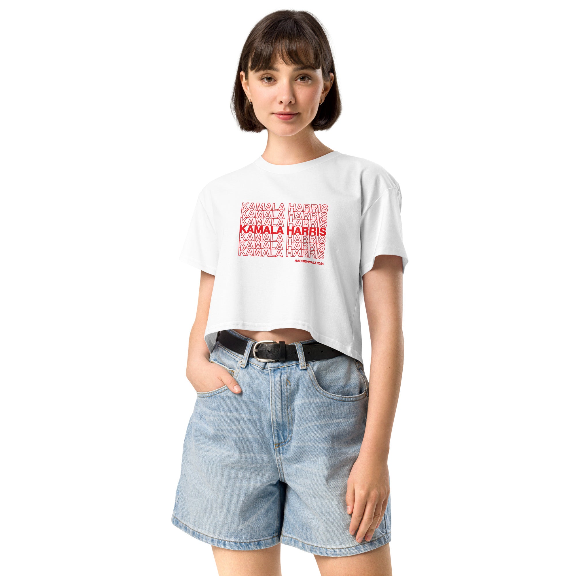 woman wearing White women's crop top t-shirt with red text saying "kamala Harris" in the classic plastic shopping bag design