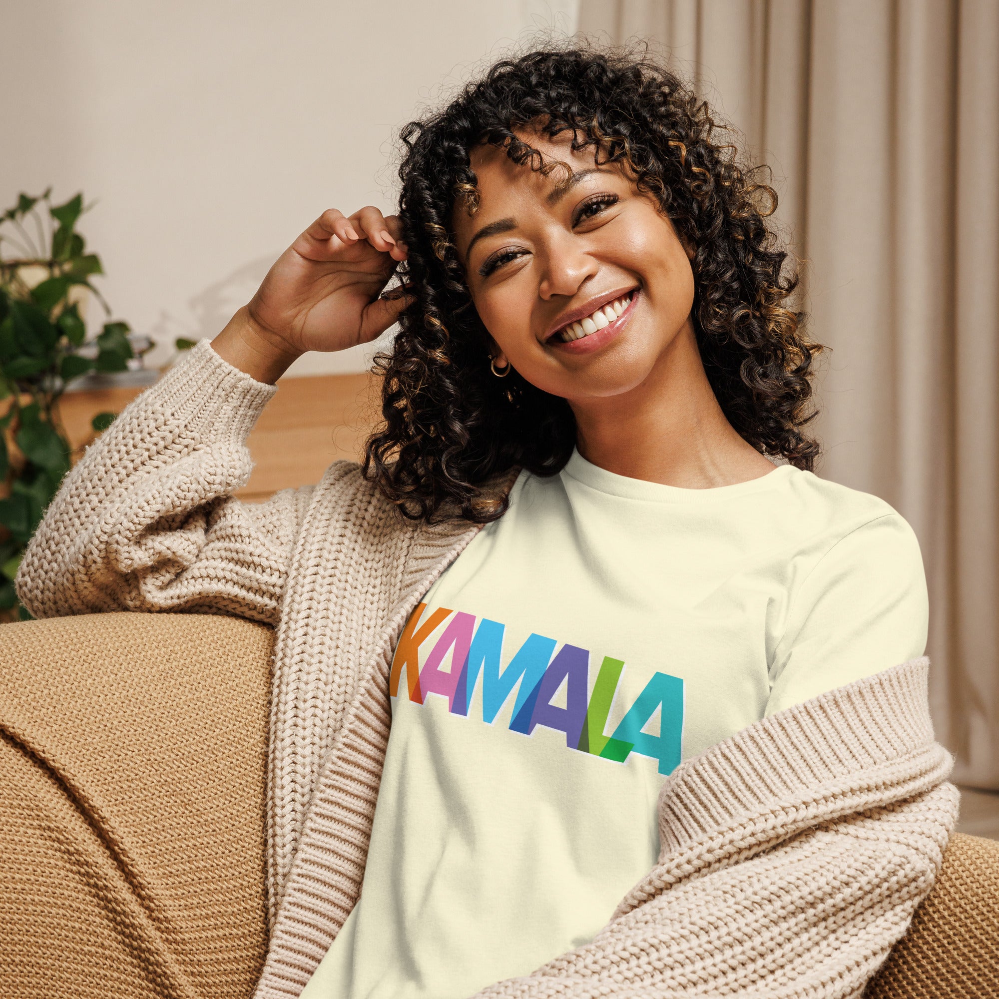 woman wearing citron colored women's t-shirt with KAMALA on the front with multi colored overlapping letters