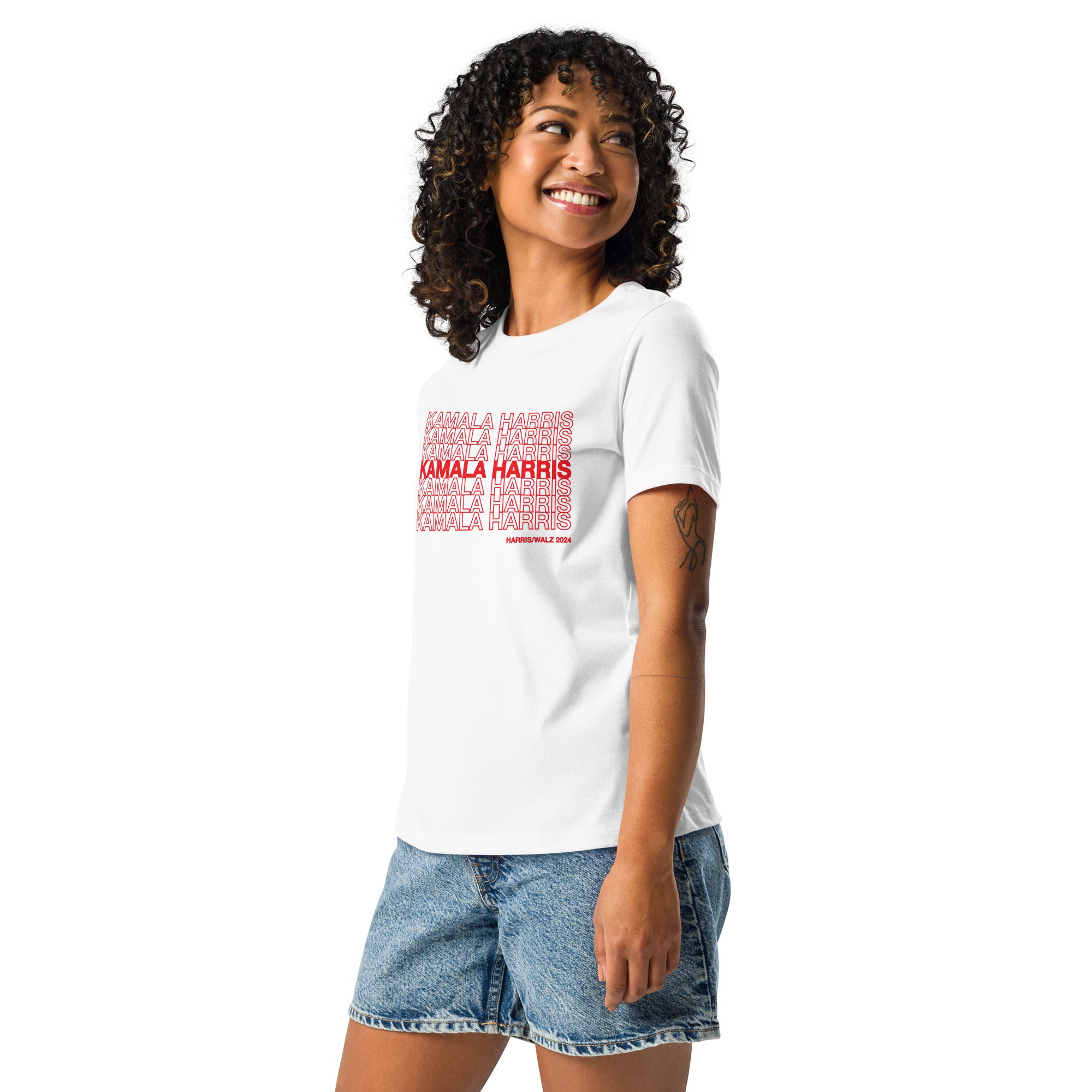 woman wearing White women's t-shirt with red text saying "kamala Harris" in the classic plastic shopping bag design