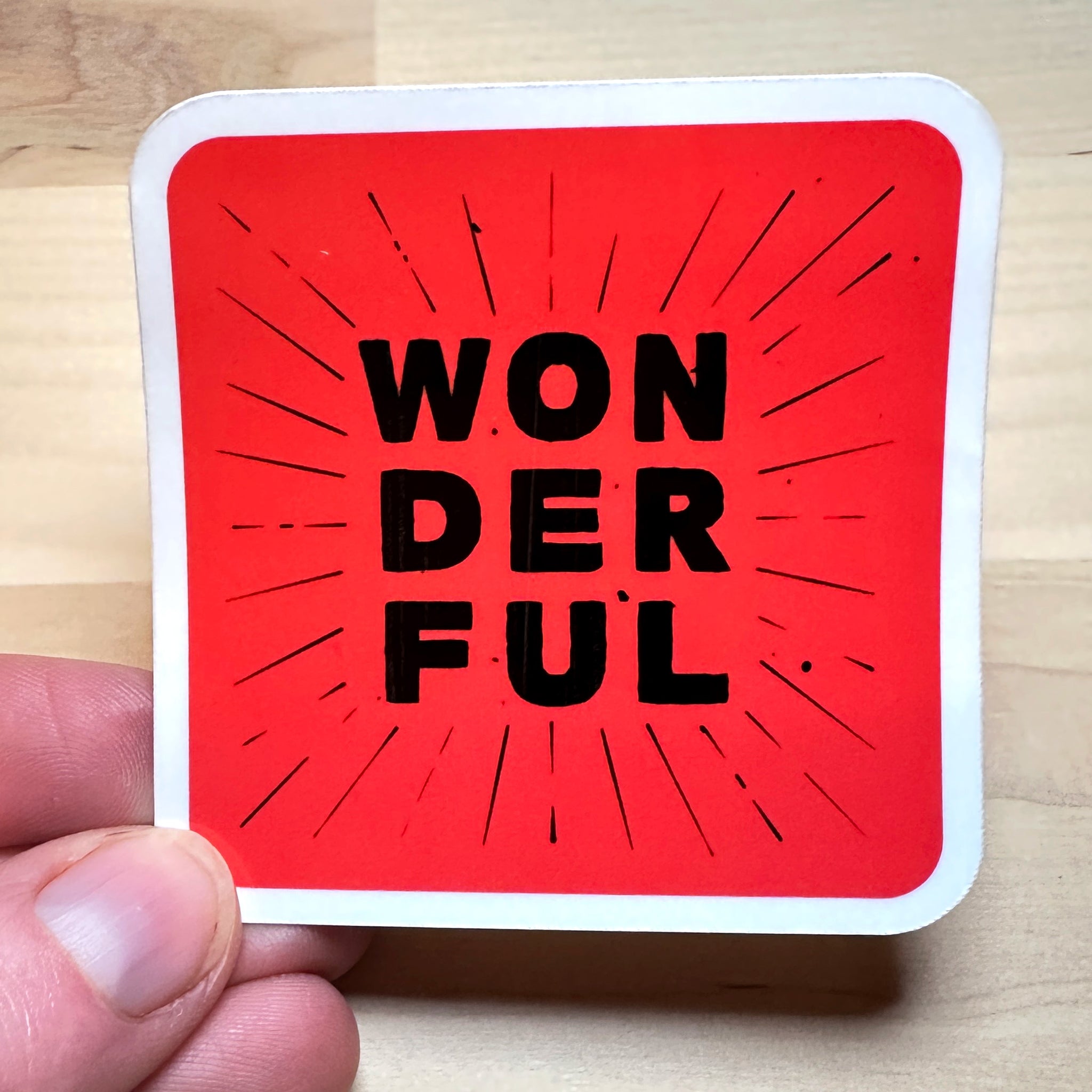 photo of waterproof vinyl sticker with the word wonderful in 3 layers of black text on red background